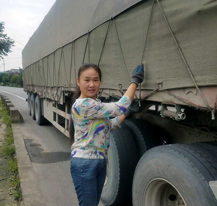 Miao Huiling tightens ropes along the truck. Courtesy of Transfar Harbour