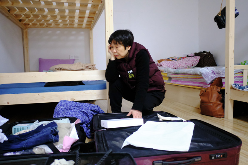 Shang Yao unpacks her son’s belongings at Home of the Stars, in Jinzhai County, Anhui province, March 2021. Wu Huiyuan/Sixth Tone