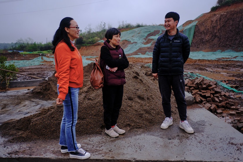 Tian Hanfen (left) and a staff member (right) accompany Shang Yao (center) to visit the construction site, in Jinzhai County, Anhui province, March 2021. It was Shang’s first time visiting the site of her future home. Wu Huiyuan/Sixth Tone