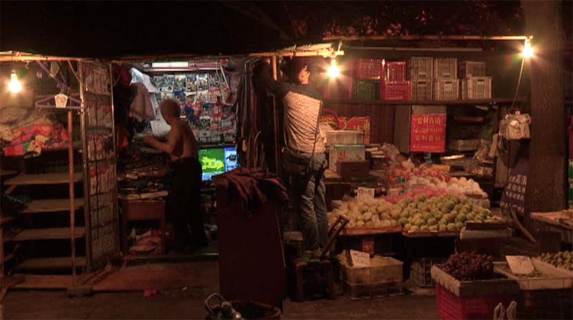 A screenshot from the film shows Wang Tiancheng (left) and his son at their street stall. Courtesy of Dai Nianwen