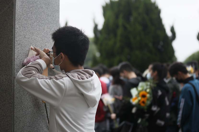 A man writes a note to Yuan Longping at the Mingyangshan Funeral Home in Changsha, Hunan province, May 23, 2021. People Visual
