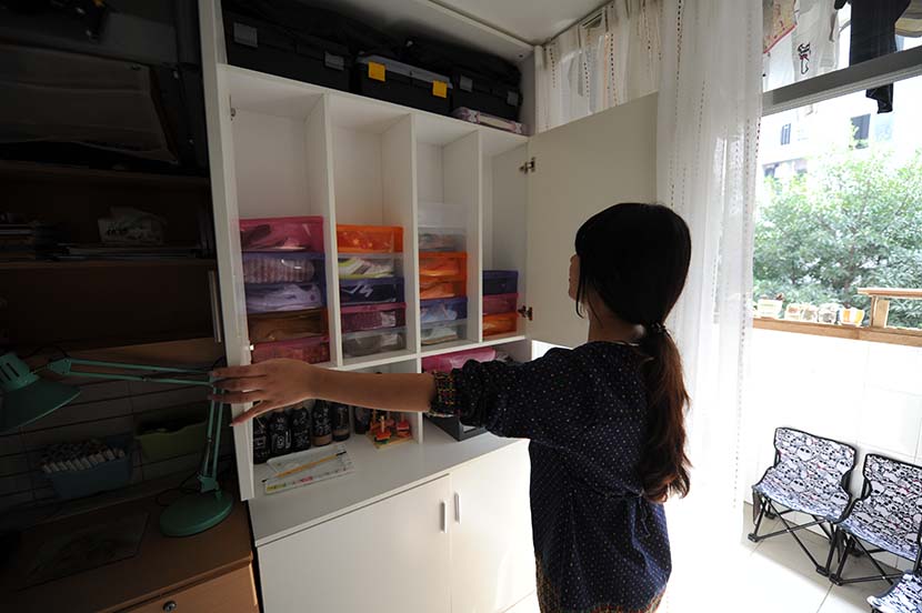 A girl opens a closet at her dormitory in Changsha, Hunan province, Oct. 23, 2015. People Visual