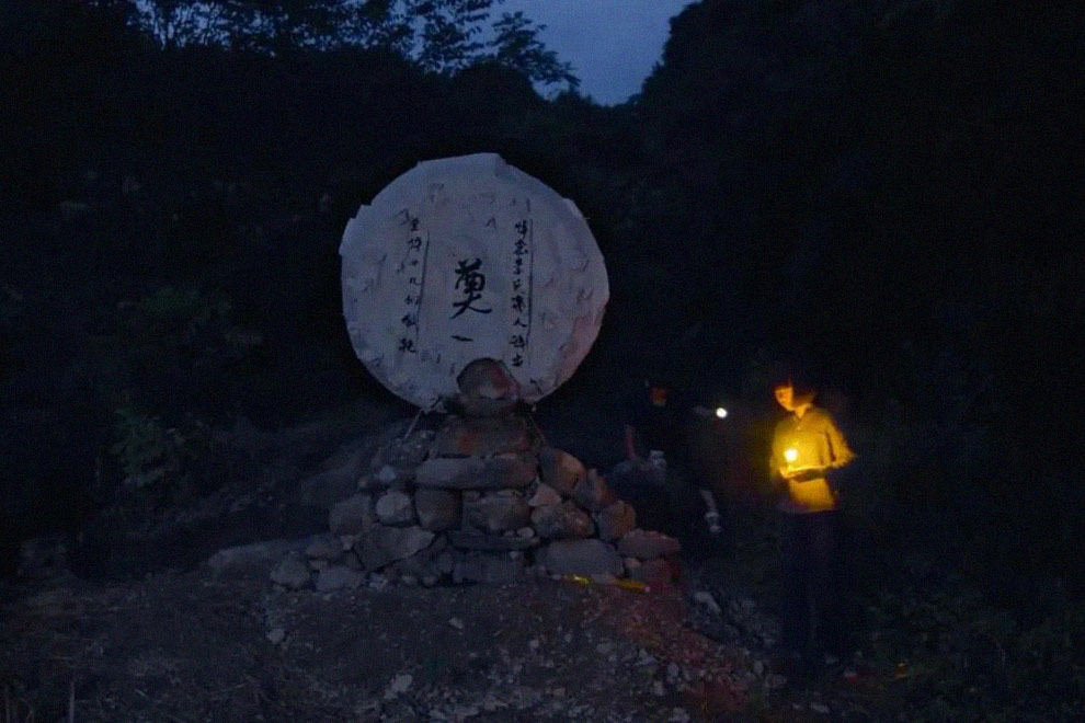 A still from “Mama” showing Xiaoxian and her younger sister lighting lamps for their deceased mother. Courtesy of Li Dongmei