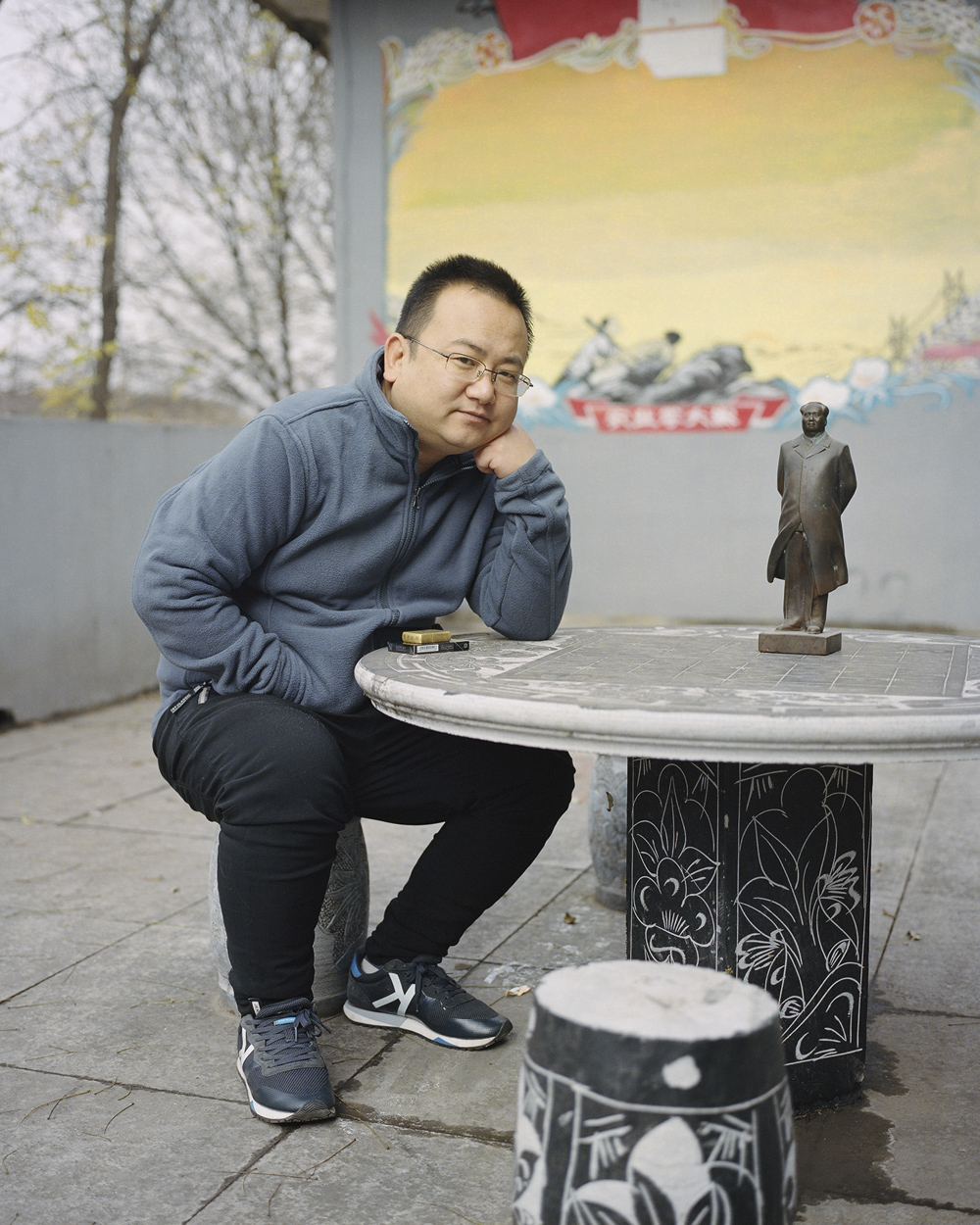 Zhao Mingxing poses for a photo with a Mao statue at his museum in Dazhai Village, Shanxi province, Nov. 17, 2018. Shi Yangkun/Sixth Tone