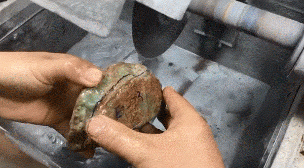 A GIF shows the process of cutting a rough stone to determine the quality of the jadeite within. From bilibili user 边境淘客光哥