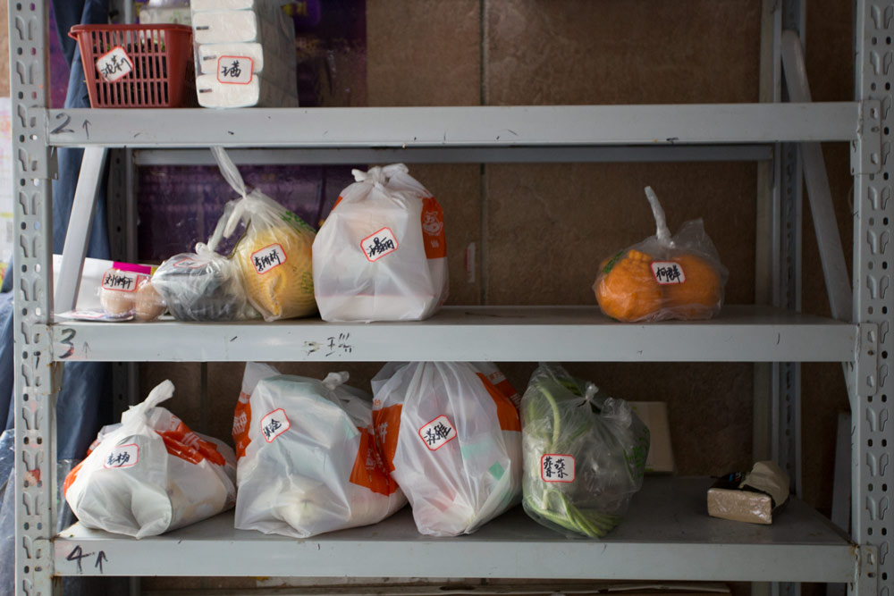 Groceries sit on a set of shelves, waiting to be collected by local residents, in Wuhan, Hubei province, April 25, 2021. Wu Peiyue for Sixth Tone