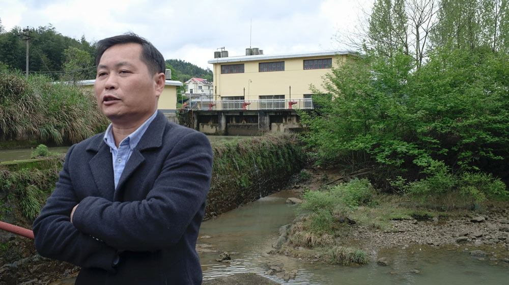 Chen Tai’an poses for a photo atop the Hongsha Hydropower Station dam in Liuyang, Hunan province, 2021. Diao Fanchao for Sixth Tone