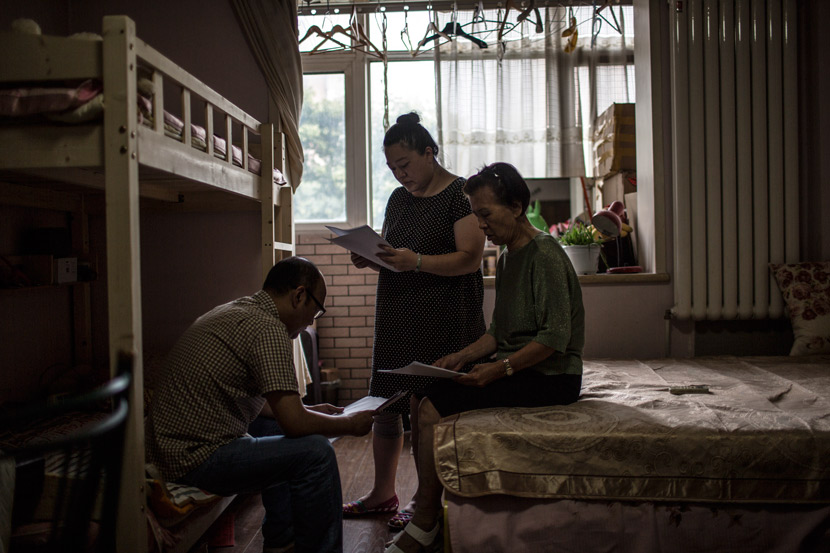 From right to left, Li Shuda, her daughter, and her son-in-law talk among themselves at a rental apartment in Beijing, July 12, 2017. Zhao Heting/Tencent News