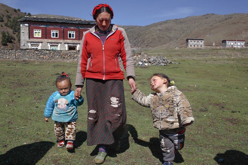 Wosar Lhamo takes her sons for a walk in Tagong Township, Kangding County, Sichuan province, May 9, 2017. Zhou Pinglang/Sixth Tone