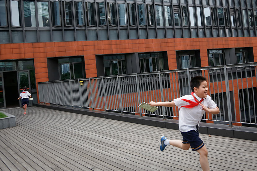 A student runs outside an elementary school building after class in Shanghai, Sept. 24, 2013. Lan Hui for Sixth Tone