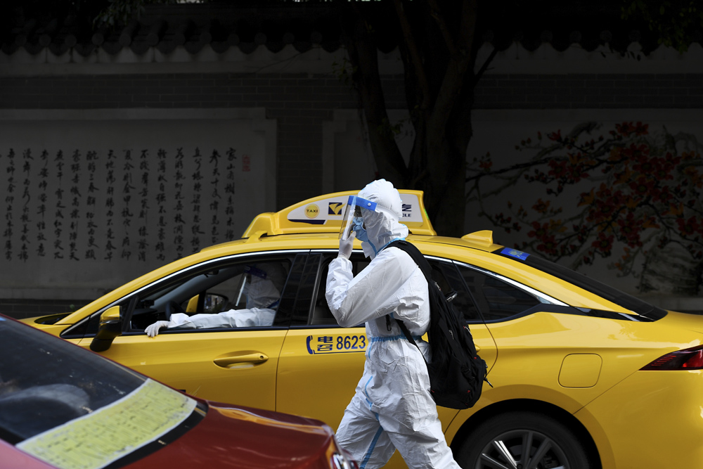 An examinee wearing protective clothing walks out of an examination site in Guangzhou, Guangdong province, June 7, 2021. People Visual