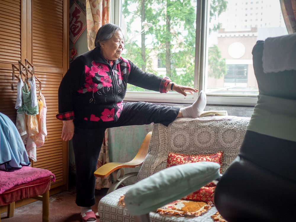 Yi Shijuan does some exercises at her home in Shanghai, April 27, 2021. Xu Haifeng for Sixth Tone