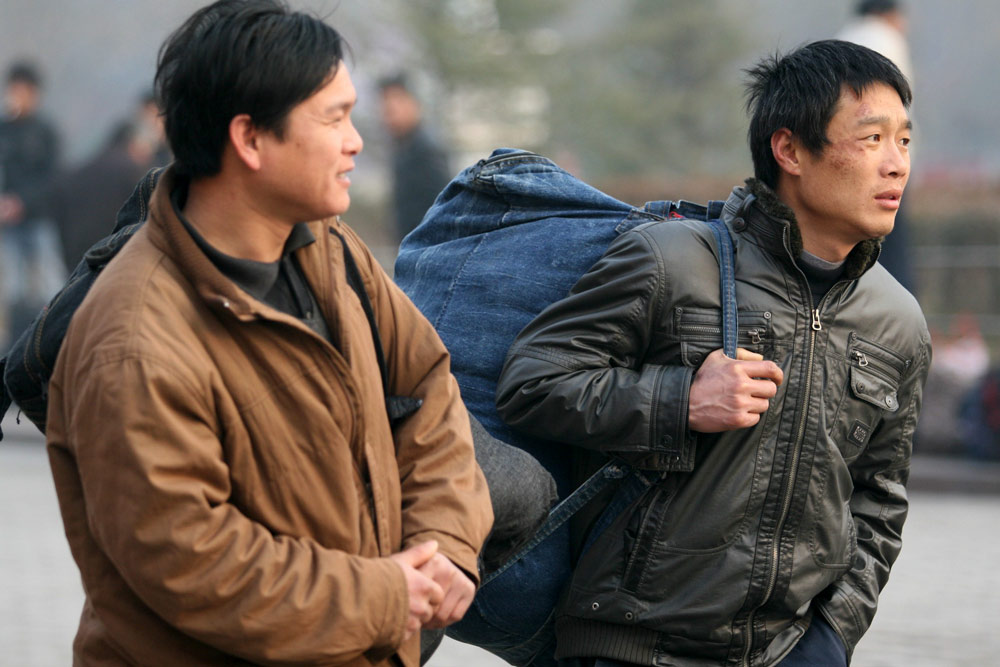 Migrant workers make their way to the railway station after the Spring Festival holiday, in Xuchang, Henan province, Feb. 3, 2009. IC