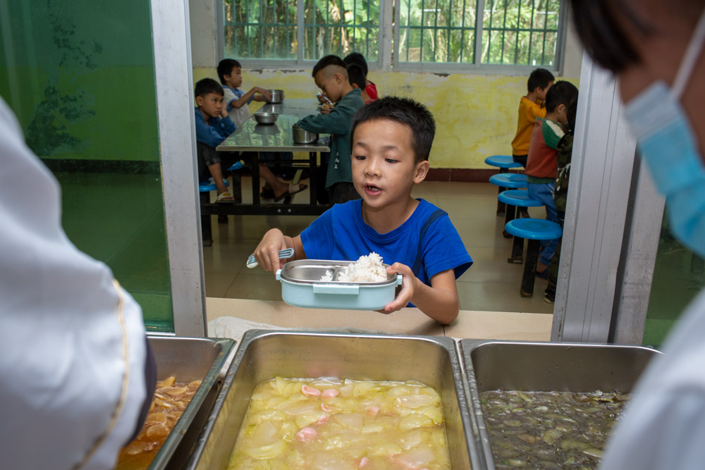 A boy waits to be served at a rural primary school in Wangxia Township, Hainan province, Dec. 9, 2020. Yuan Chen/People Visual