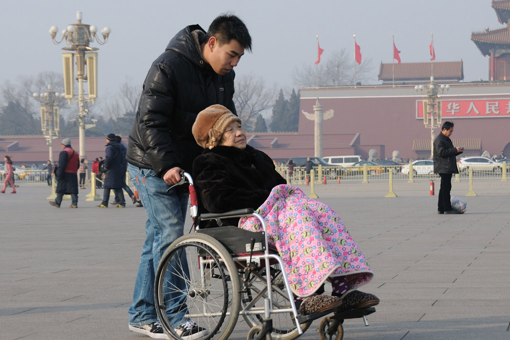 A man takes an elderly woman on a tour of Tiananmen Square in Beijing, Feb. 26, 2013. Jin Wen/People Visual