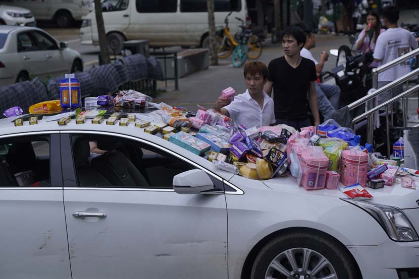 A man sells daily necessities after his grocery store was flooded on Shakou Road in Zhengzhou, Henan province, July 22, 2021. Wu Huiyuan/Sixth Tone