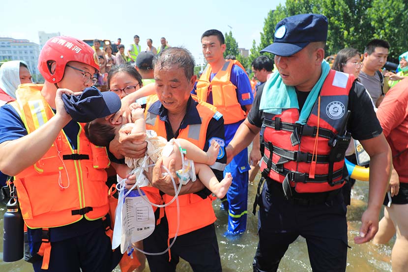 A sick baby is taken care of during the relocation of patients from the First Affiliated Hospital of Xinxiang in Weihui, Henan province, July 26, 2021. People Visual