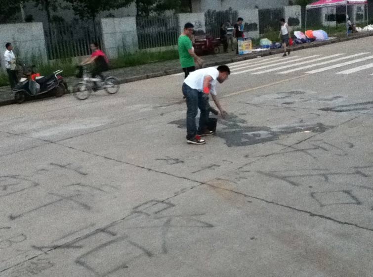 Ge Yulu covers up his graffiti using cement, in Wuhan, Hubei province. Courtesy of Ge Yulu