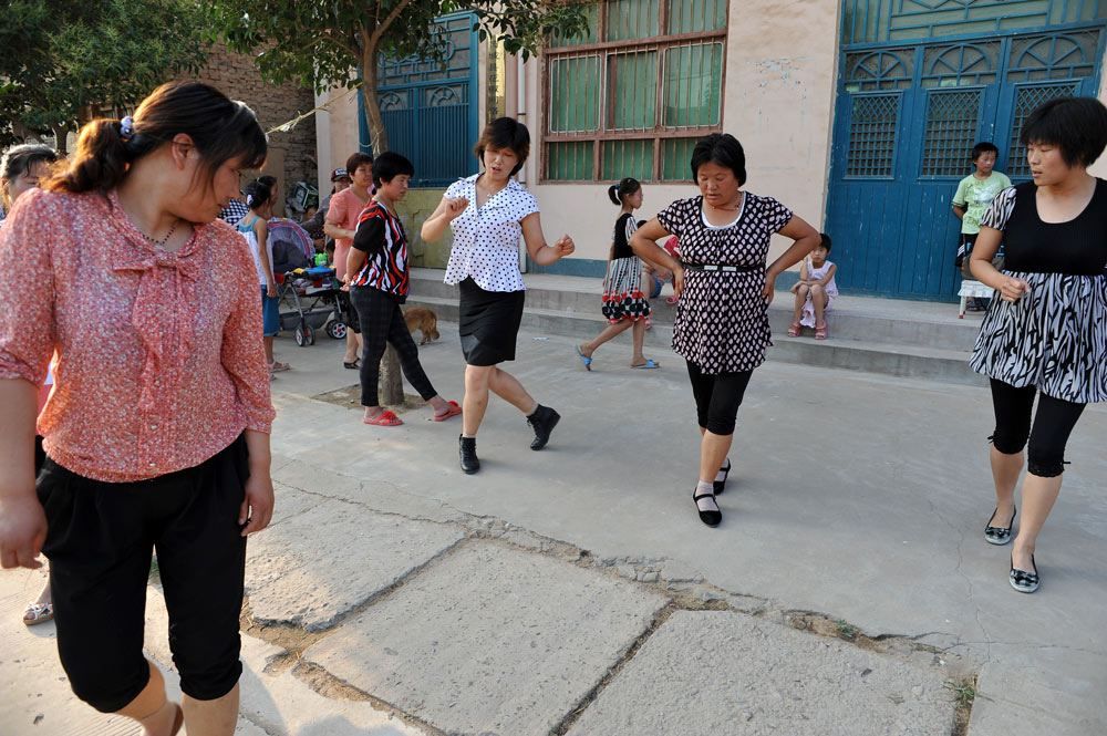 Women teach each other a new dance in Qili Village, Shanxi province, June 2012. Liu Baocheng/People Visual