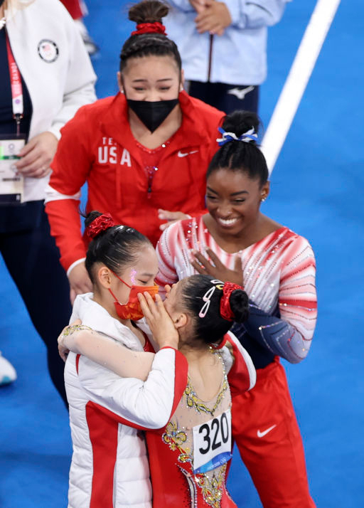 Tang Xijing and Guan Chenchen (No. 320) celebrate after the women’s balance beam final as the United States’ Simone Biles and Sunisa Lee look on, Aug. 3, 2021. Zheng Huansong/Xinhua