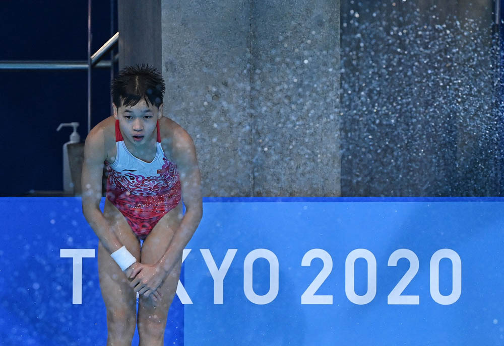 Quan Hongchan waits by the pool to see her final score during the women’s 10-meter platform diving final, Aug. 5, 2021. Quan would go on to win the event. Attila Kisbenedek/AFP via People Visual