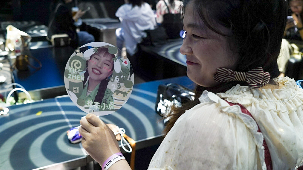A fan of Yang Yuzhen holds a fan with a picture of Yang’s face, Shanghai, June 22, 2021. Fu Beimeng/Sixth Tone