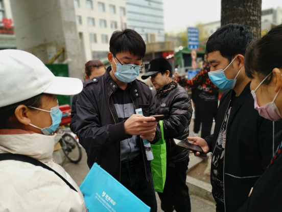 Lu (center) promotes his services outside a hospital. Courtesy of Lu