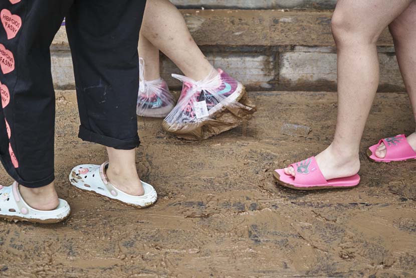 A woman wears plastic bags to cover her shoes in Mihe Town, Henan province, July 23, 2021. Wu Huiyuan/Sixth Tone