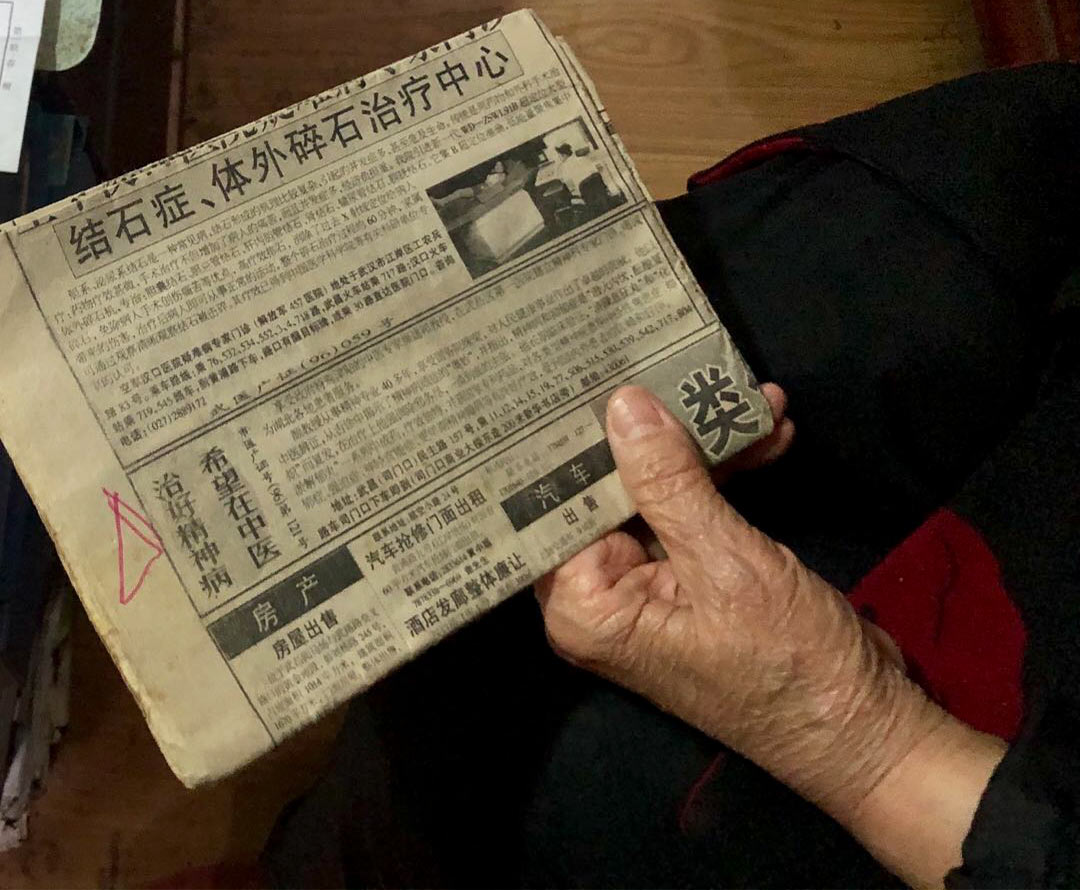 Song Mingli shows a newspaper article on traditional Chinese medicine cures for mental illness. Courtesy of Liang Ting