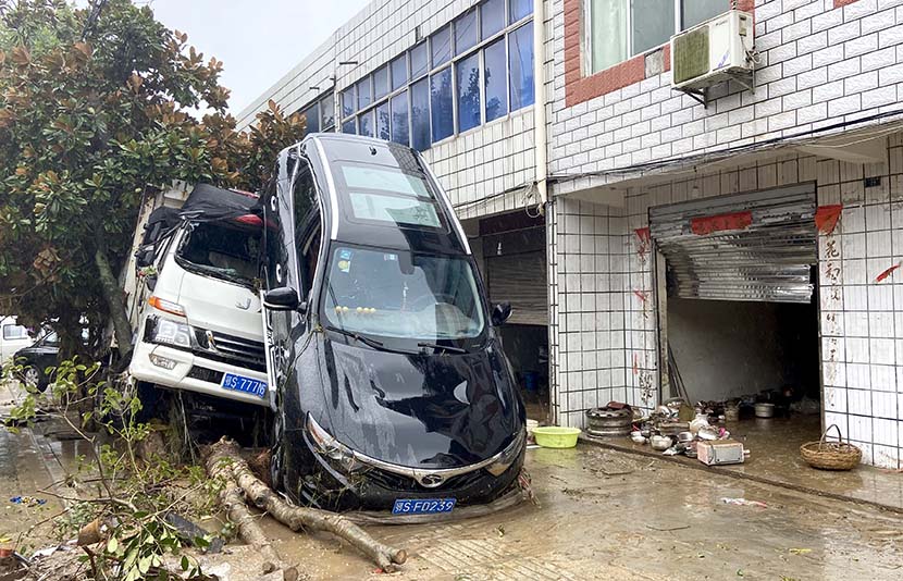 Two vehicles are damaged by flood waters in Suizhou, Hubei province, Aug. 13, 2021. People Visual