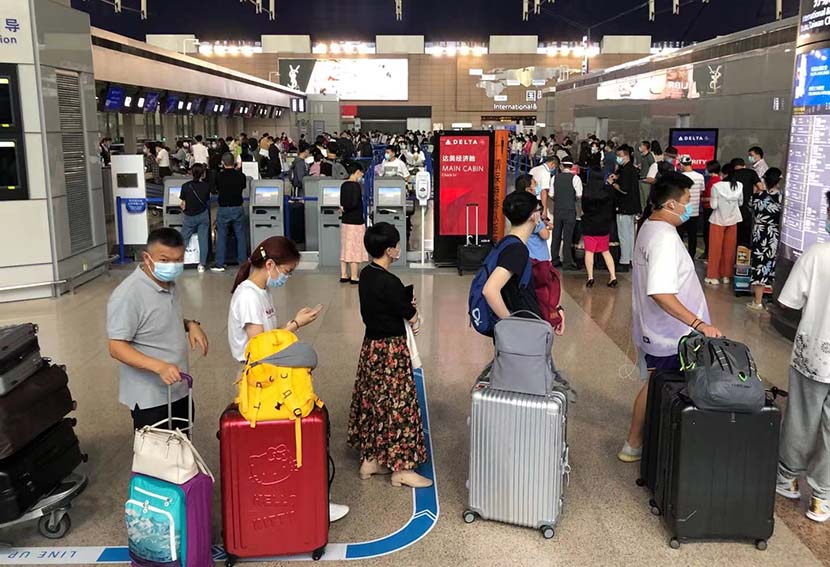 Passengers wait to check in at Shanghai Pudong International Airport, Aug. 16, 2021. Zhang Lifen for Sixth Tone