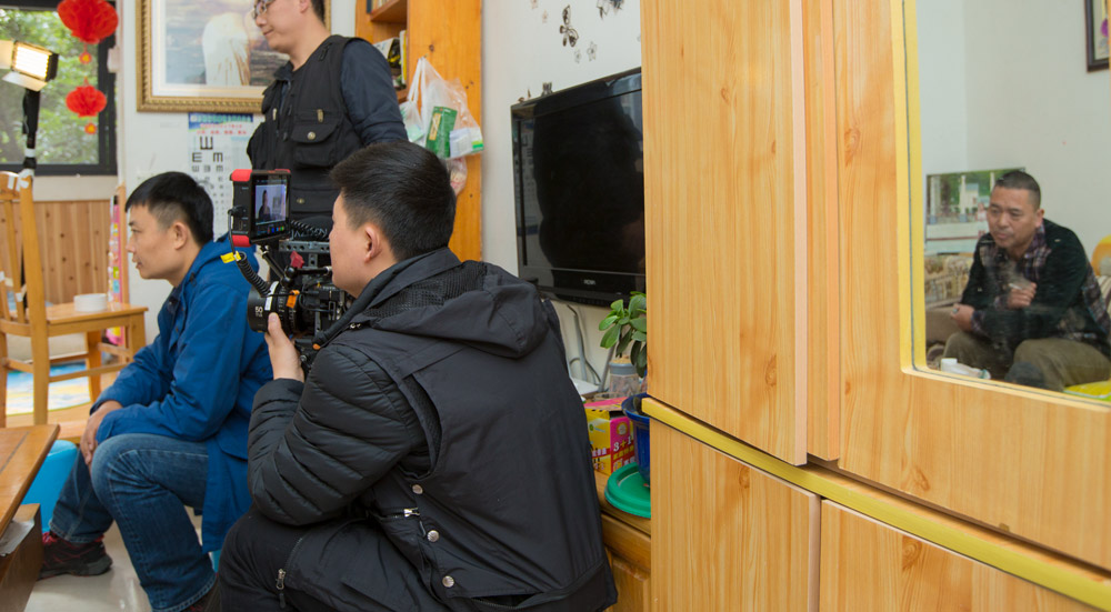Fan Jian (in blue) and a crew member shoot footage for the documentary “After the Rain.” Courtesy of Yu Zhuo