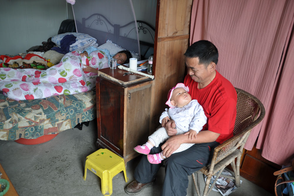 A still from the 2011 documentary “The Next Life” shows Zhu Junsheng holding his friend's newborn son. From Douban