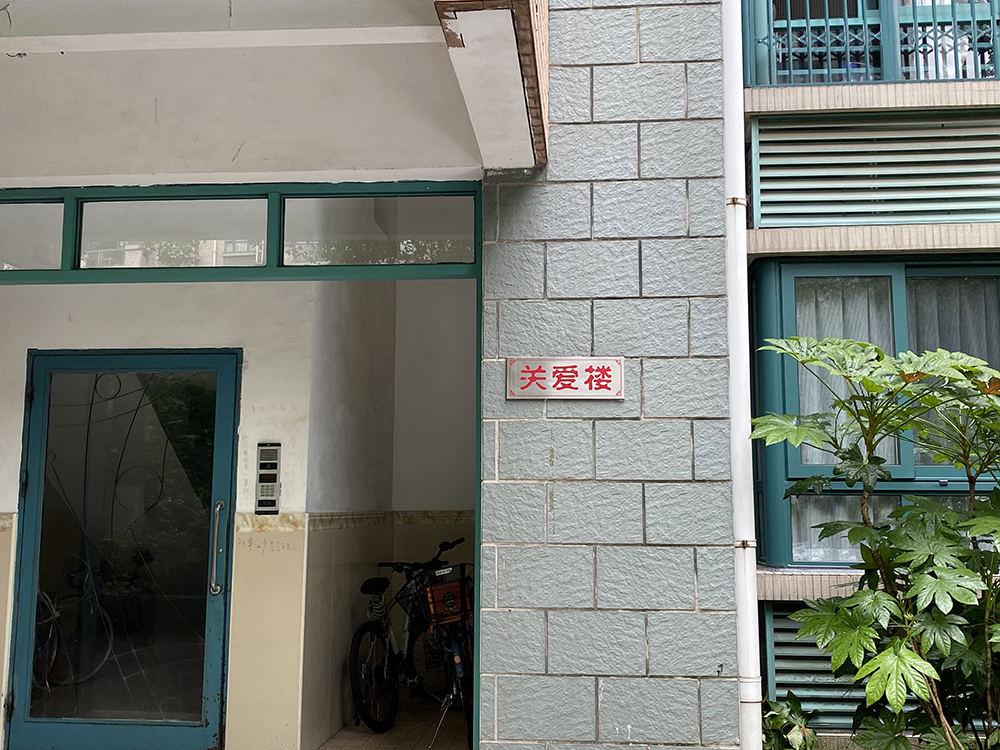 The entrance to the building where the conflict took place, Shanghai, 2021. The sign reads “care for the building.” Chen Canjie for Sixth Tone