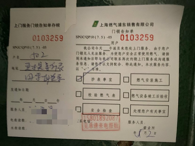 A notice regarding a replacement gas meter left on the door of Apartment 502, Shanghai, 2021. Chen Canjie for Sixth Tone