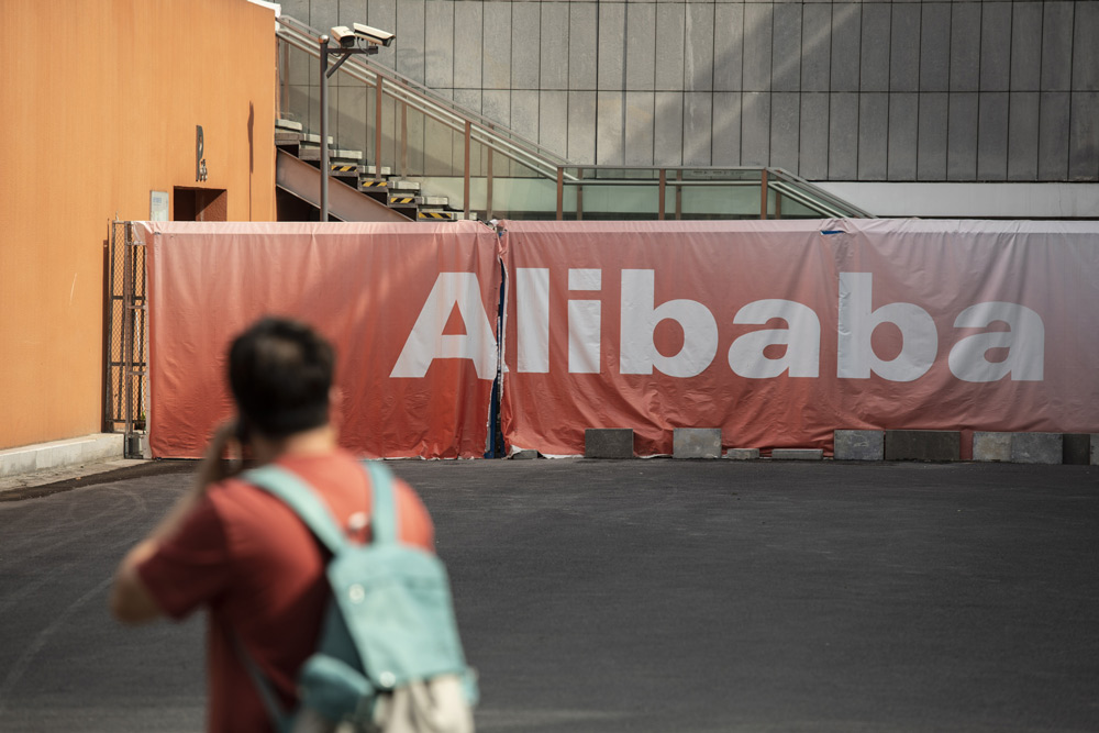 A man walks past a sign at Alibaba’s headquarters in Hangzhou, Zhejiang province, May 8, 2021. Qilai Shen/Bloomberg via People Visual