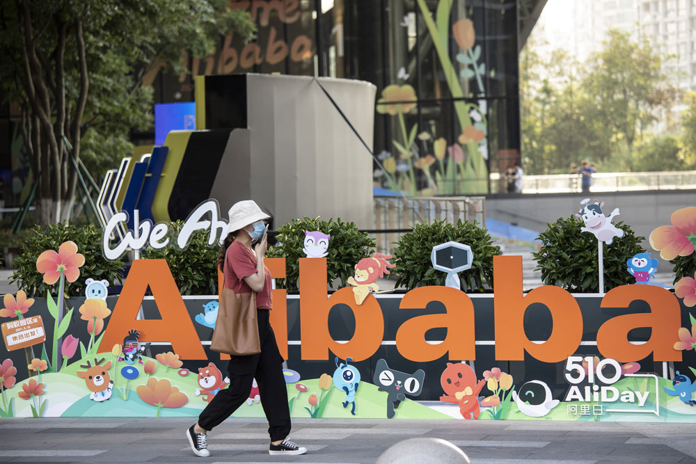 A woman walks past a sign at Alibaba’s headquarters in Hangzhou, Zhejiang province, May 8, 2021. Qilai Shen/Bloomberg via People Visual