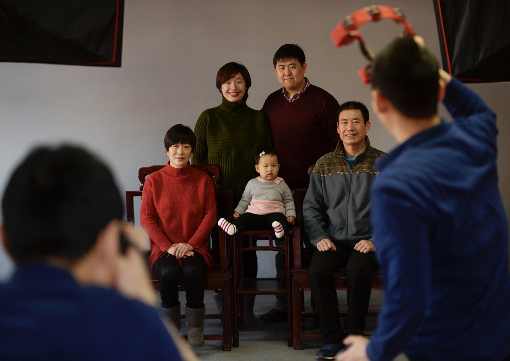 A family poses for a family portrait at a photo studio in Beijing, 2017. Hao Yi and Wang Weiwen/Beijing Youth Daily/People Visual