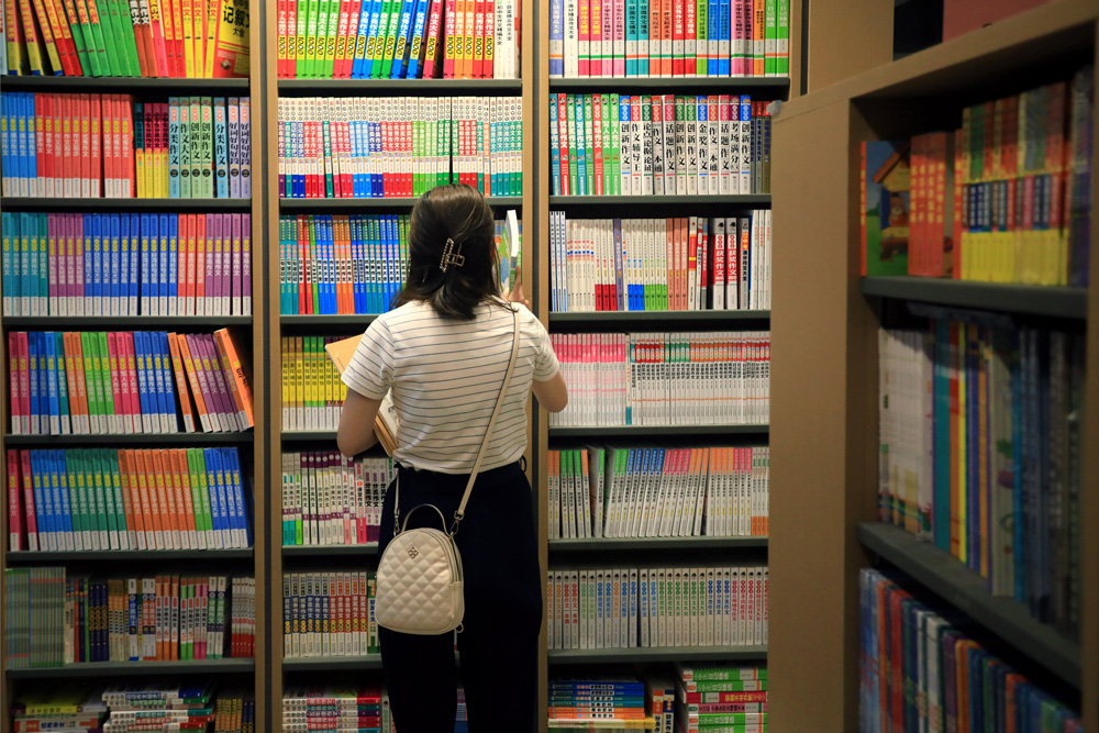 A woman picks out supplementary study materials at a bookstore in Huai’an, Jiangsu province, Aug. 29, 2021. Zhou Changguo/IC