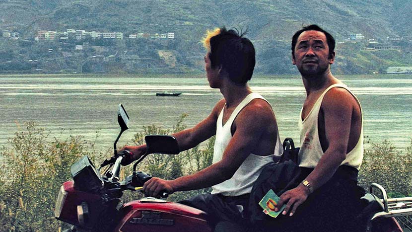 A still from “Still Life” shows the actor Han Sanming (right), who used to be a miner, riding on the back of a motorbike. From Douban