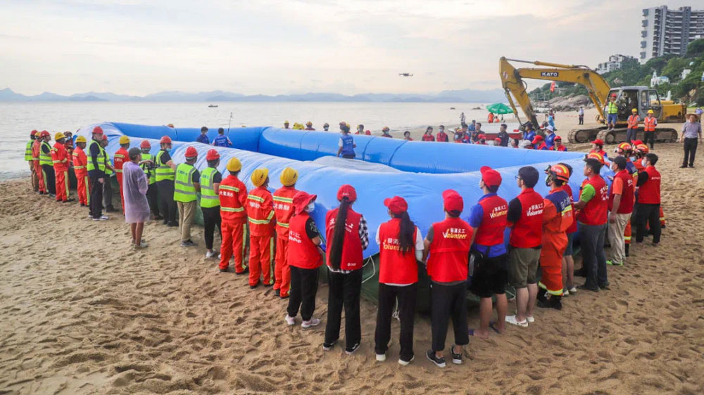 Rescue workers and volunteers take part in a whale rescue training exercise organized by the government of Dapeng New District to prepare for the possibility of Xiaobu ending up stranded, in Shenzhen, Guangdong province, July 2021. From 爱大鹏 on WeChat