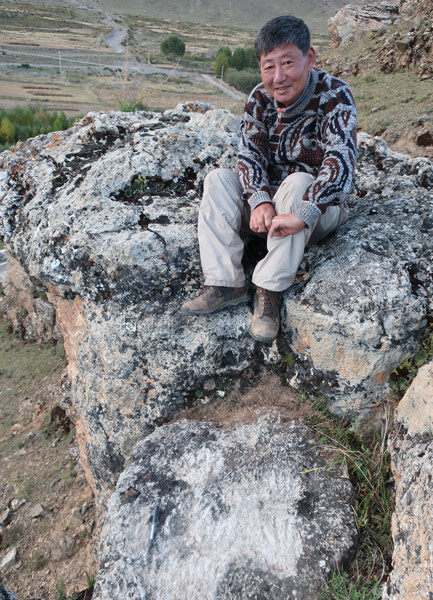 Dr. David Dian Zhang poses for a photo with the ancient hand and foot prints (below) in Tibet Autonomous Region, 2018. Courtesy of David Dian Zhang