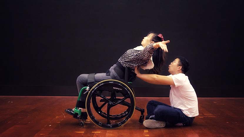 Pan Jing practices wheelchair dancing with the help of her husband. Chen Si/Sixth Tone