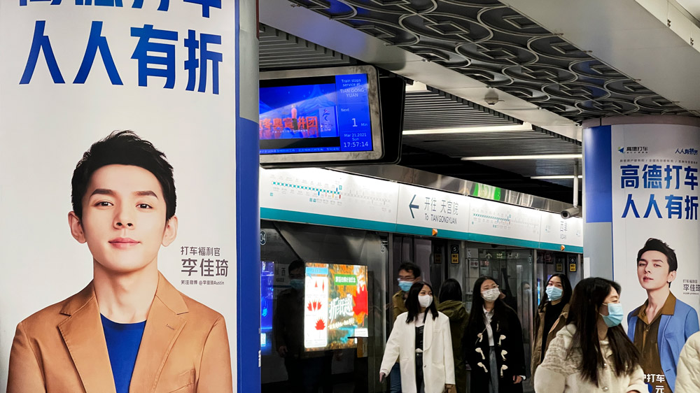 Commuters walk past a billboard bearing Li Jiaqi’s face in Beijing, March 2021. People Visual