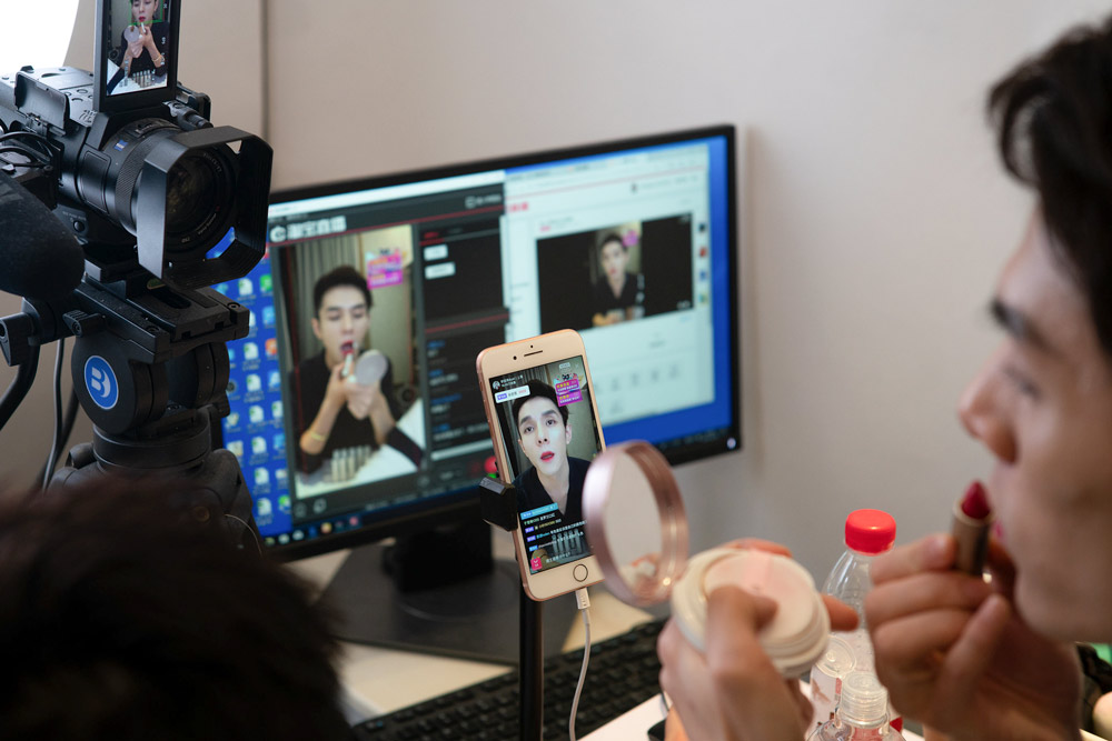 Li Jiaqi tries on lipstick during a livestream in Shanghai, 2018. Niu Jing/People Visual