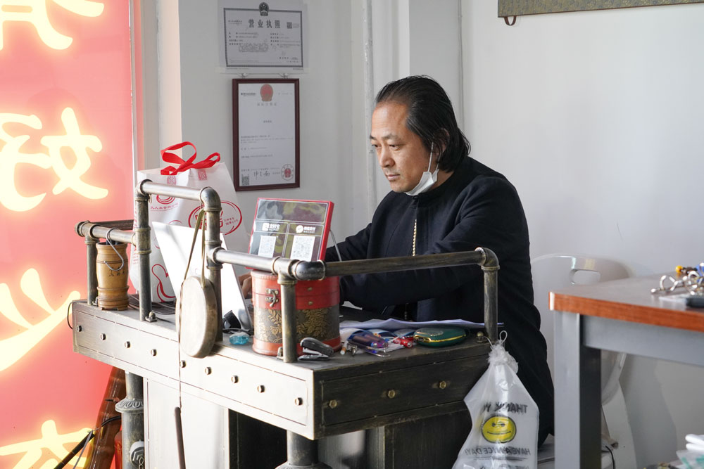 Song Delong works on his laptop at his elderly toy store in Beijing, May 2021. Courtesy of Song Delong