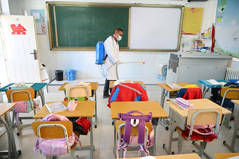 A man sterilizes a classroom in Hohhot, Inner Mongolia Autonomous Region, Oct. 26, 2021. Liu Wenhua/CNS/People Visual