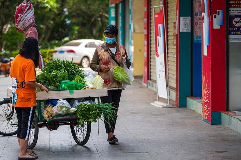A woman purchases vegetables in Ruili, Yunnan province, Oct. 2, 21021. People Visual