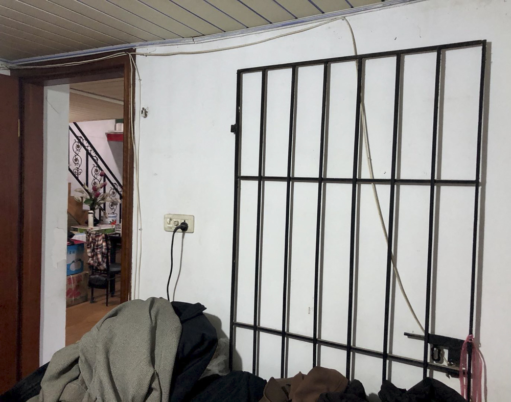 An elderly couple whose son has a mental illness place an iron gate across the door to their bedroom to protect themselves at night. Courtesy of Liang Ting