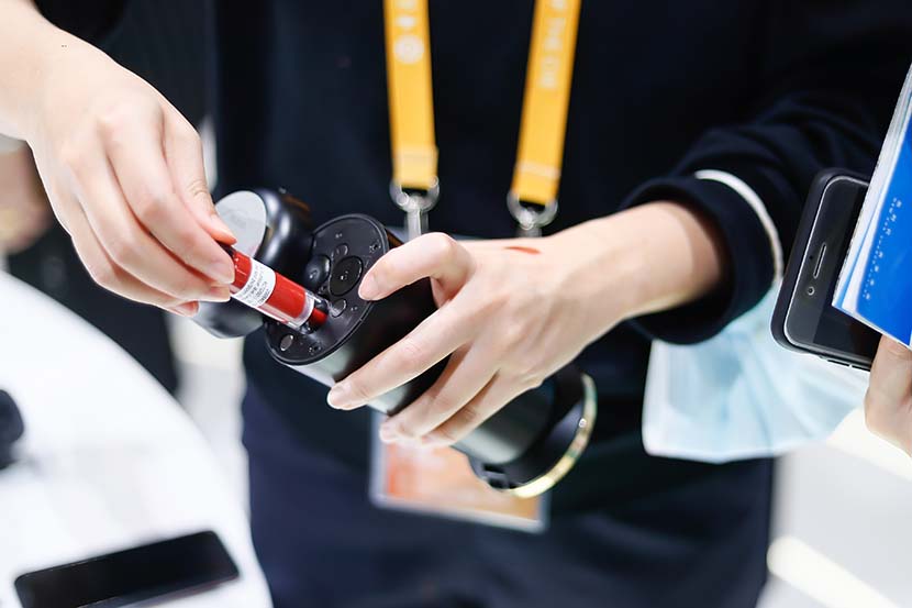 A visitor tries out the YSL lipstick printer at L’Oréal's booth at CIIE in Shanghai, Nov. 7, 2021. Courtesy of L’Oréal